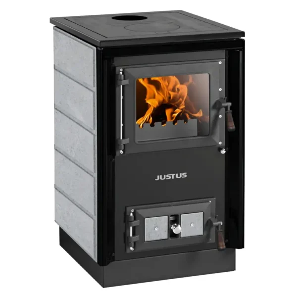 En moderne grå kleberstein peisovn, Justus Rustico 50 2.0 Kleberstein-modellen, med sort ramme, som har en stor glassdør som viser oransje flammer og glødende ved inne i ildkassen, en toppkokplate med et sentralt hull, og sidelastet askebunn med trehåndtak.